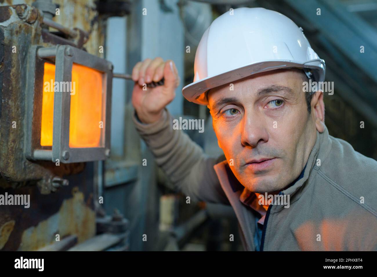 man-next-to-glowing-orange-furnace-inspection-door-stock-photo-alamy