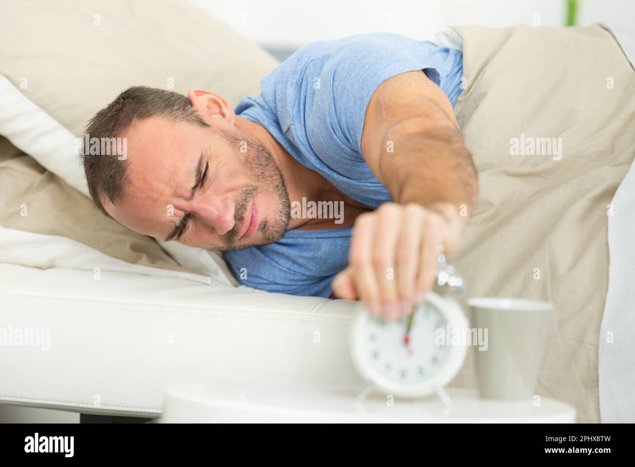man turning off the alarm clock Stock Photo Alamy