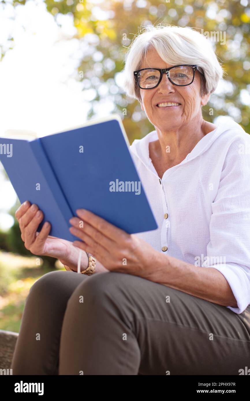 senior woman reading a book outdoors Stock Photo - Alamy