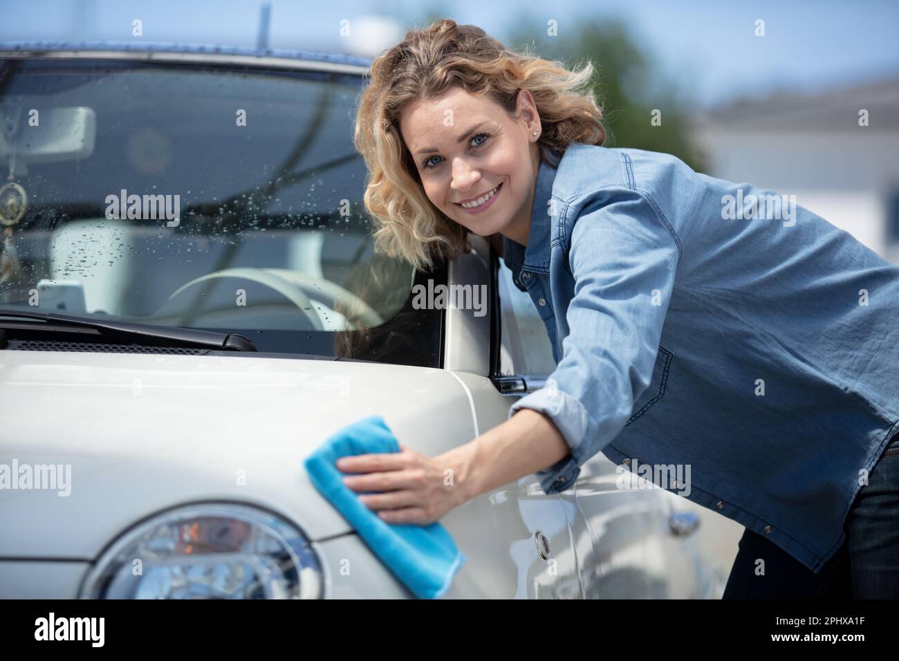 young woman dry wiping her car Stock Photo Alamy