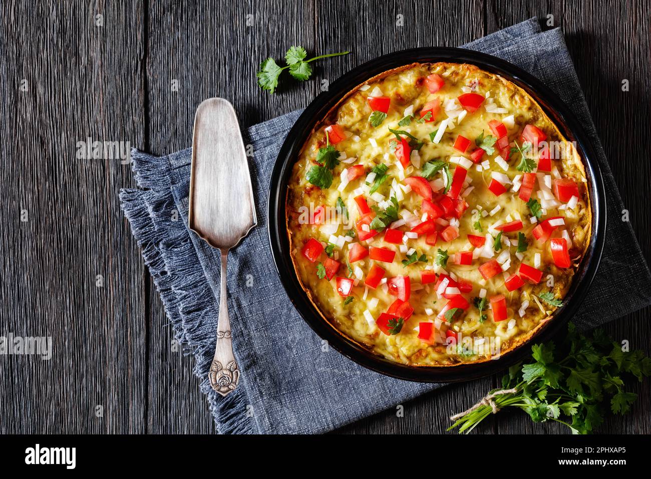Green Chile Enchilada Casserole of corn tortillas layered with refried beans, corns, sauce and
