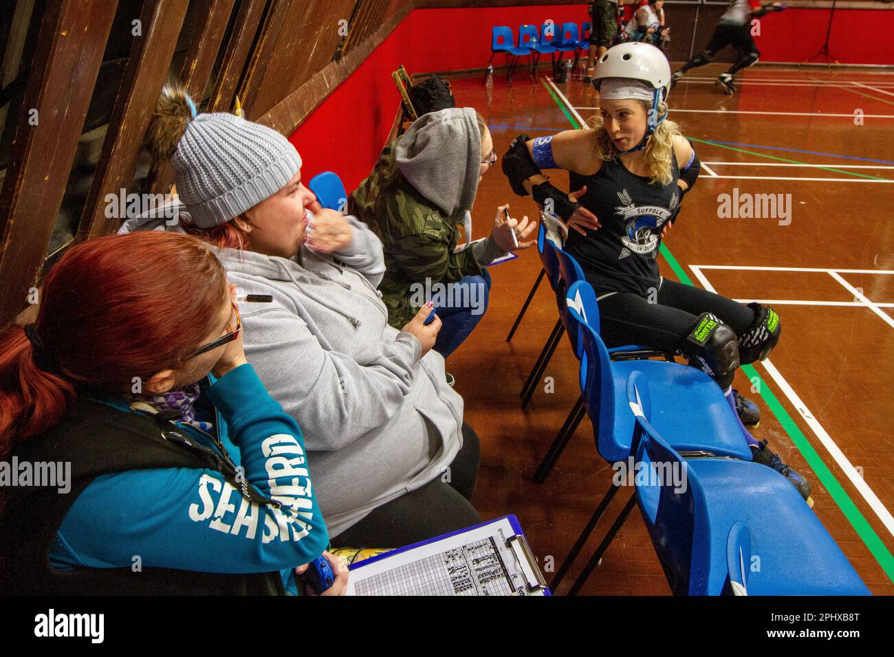 Non Skating Officials (NSOs) manage a roller derby penalty box where  penalised skaters have to wait off track to serve out there penalty Stock  Photo - Alamy