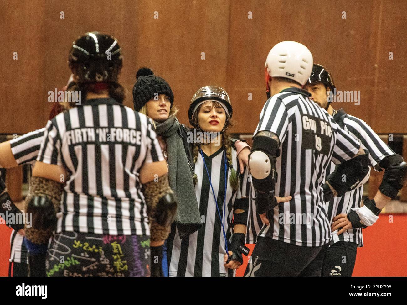 A group of roller derby refs gather in the track centre to discuss an