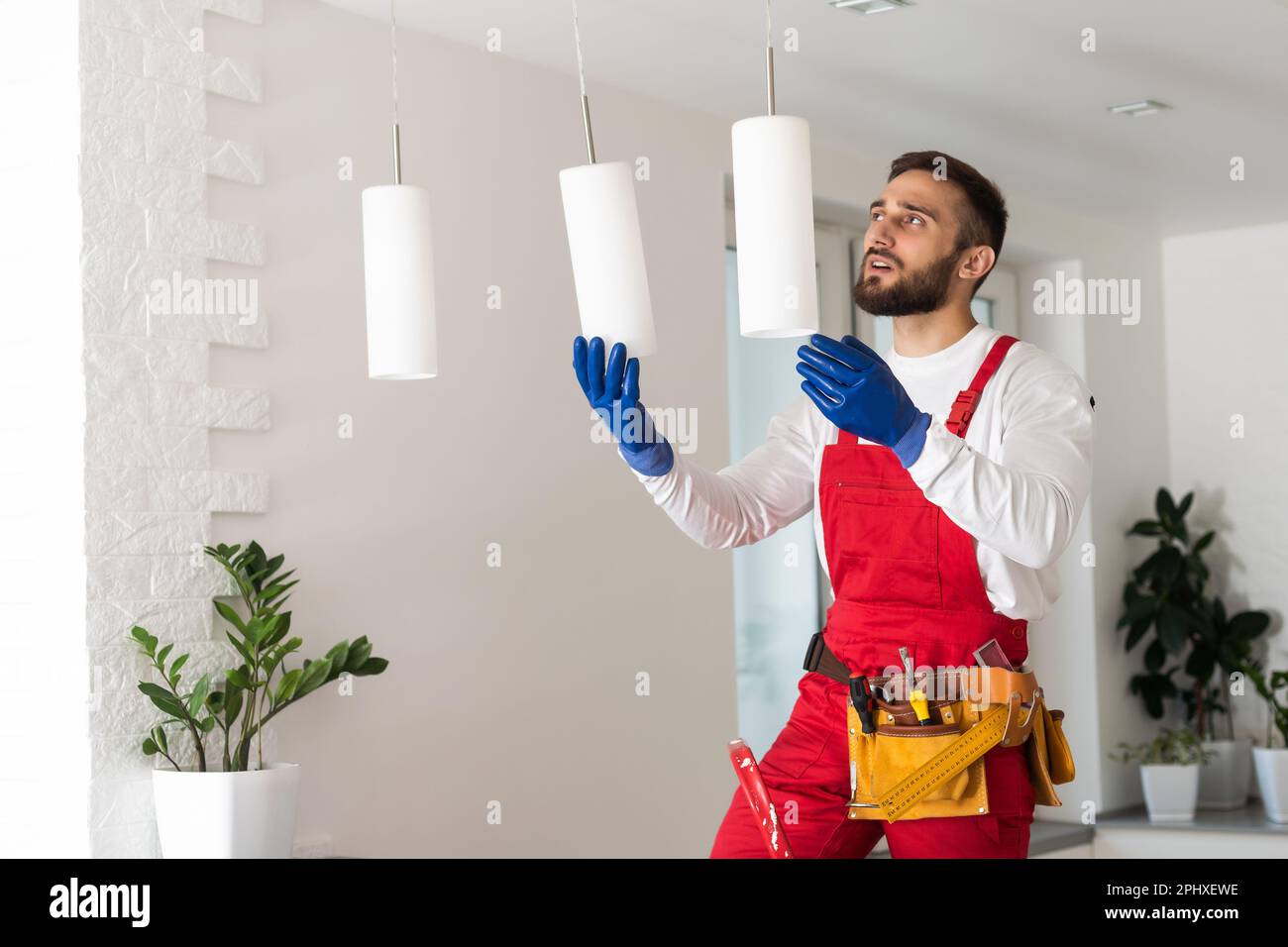 Electrician mounting ceiling lamp - installing the wires Stock Photo ...