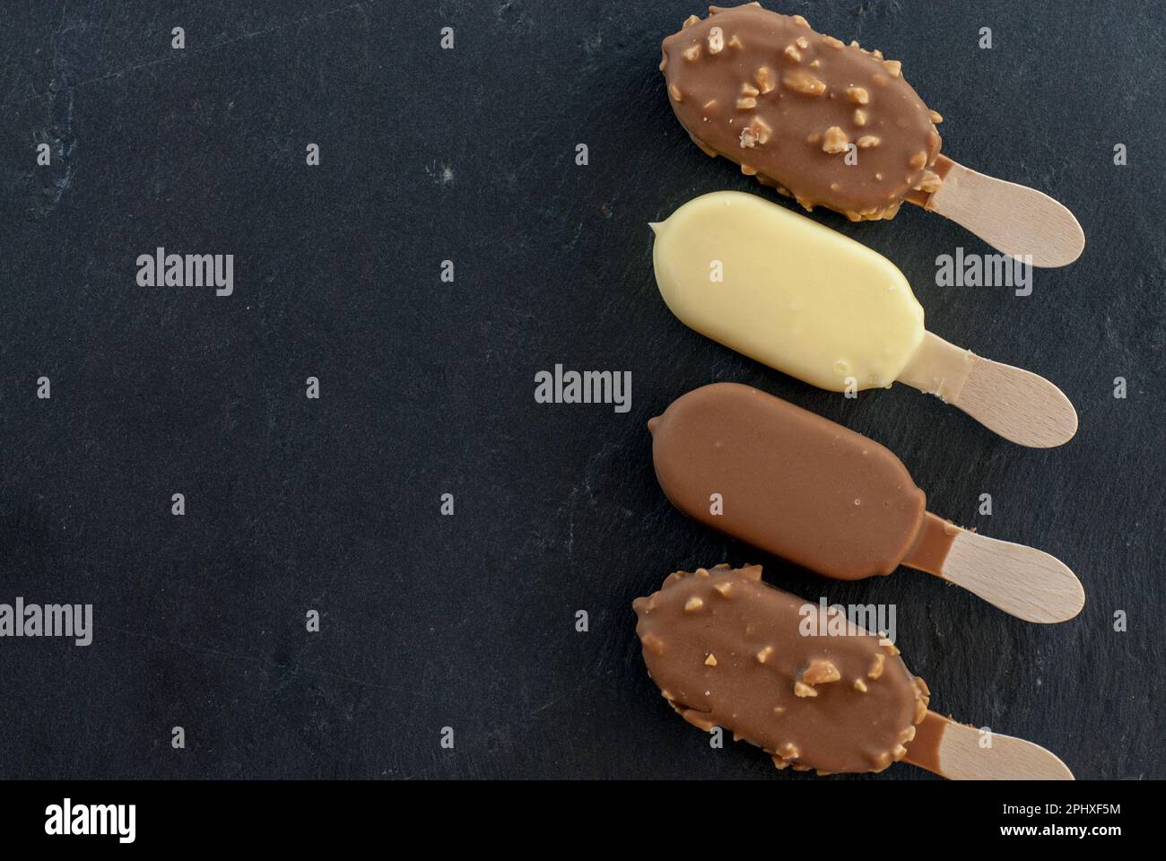 assorted mini ice creams on stick on black Stock Photo