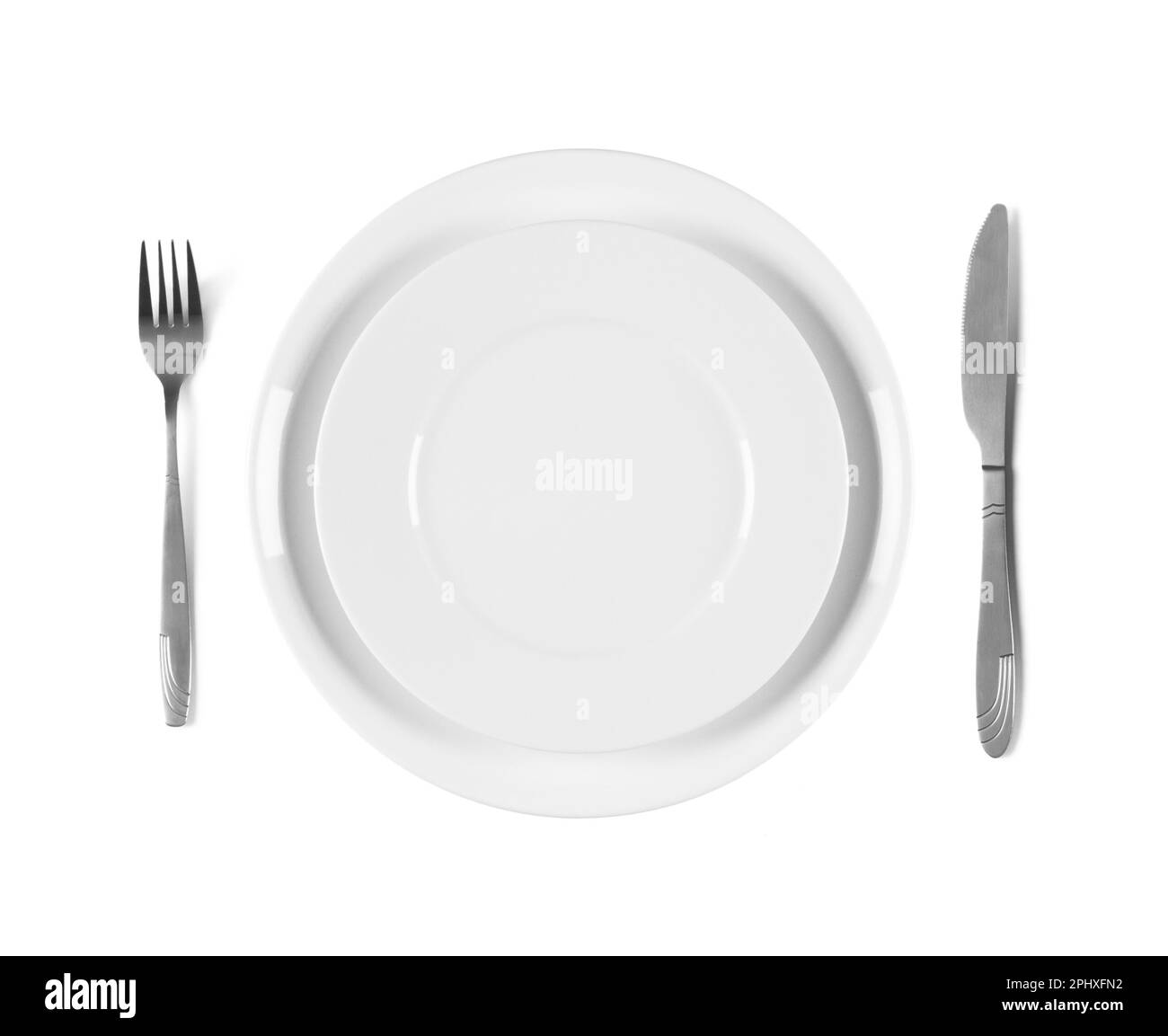 Two stacked white plates with fork and knife, overhead top view. Isolated on white background