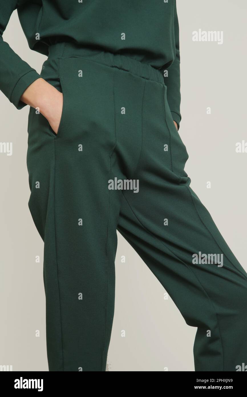 Serie of studio photos of young female model wearing comfortable green high waisted pinched seam cigarette trousers with side pockets Stock Photo