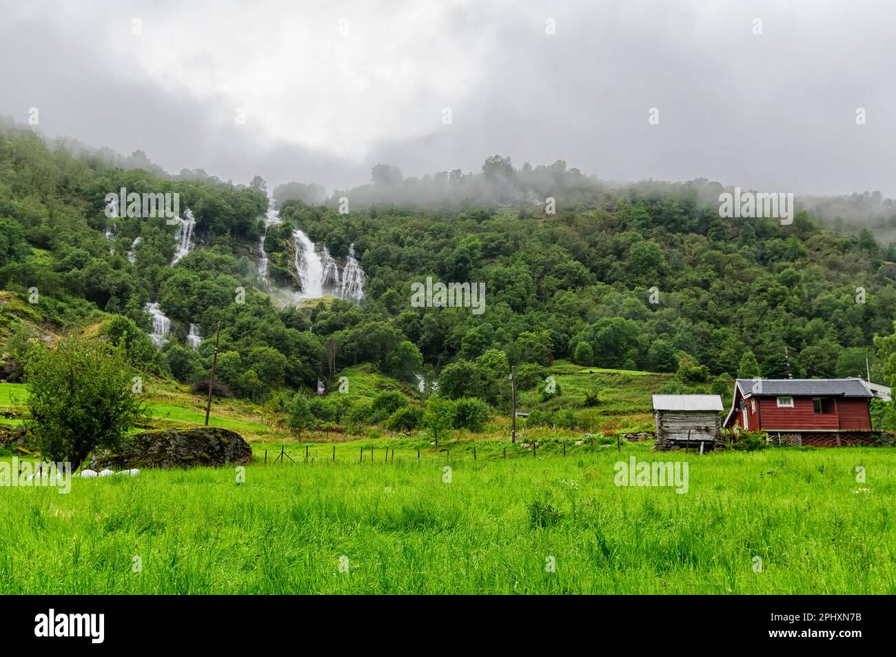 wood houses in countryside in Norway with waterfalls falling down the