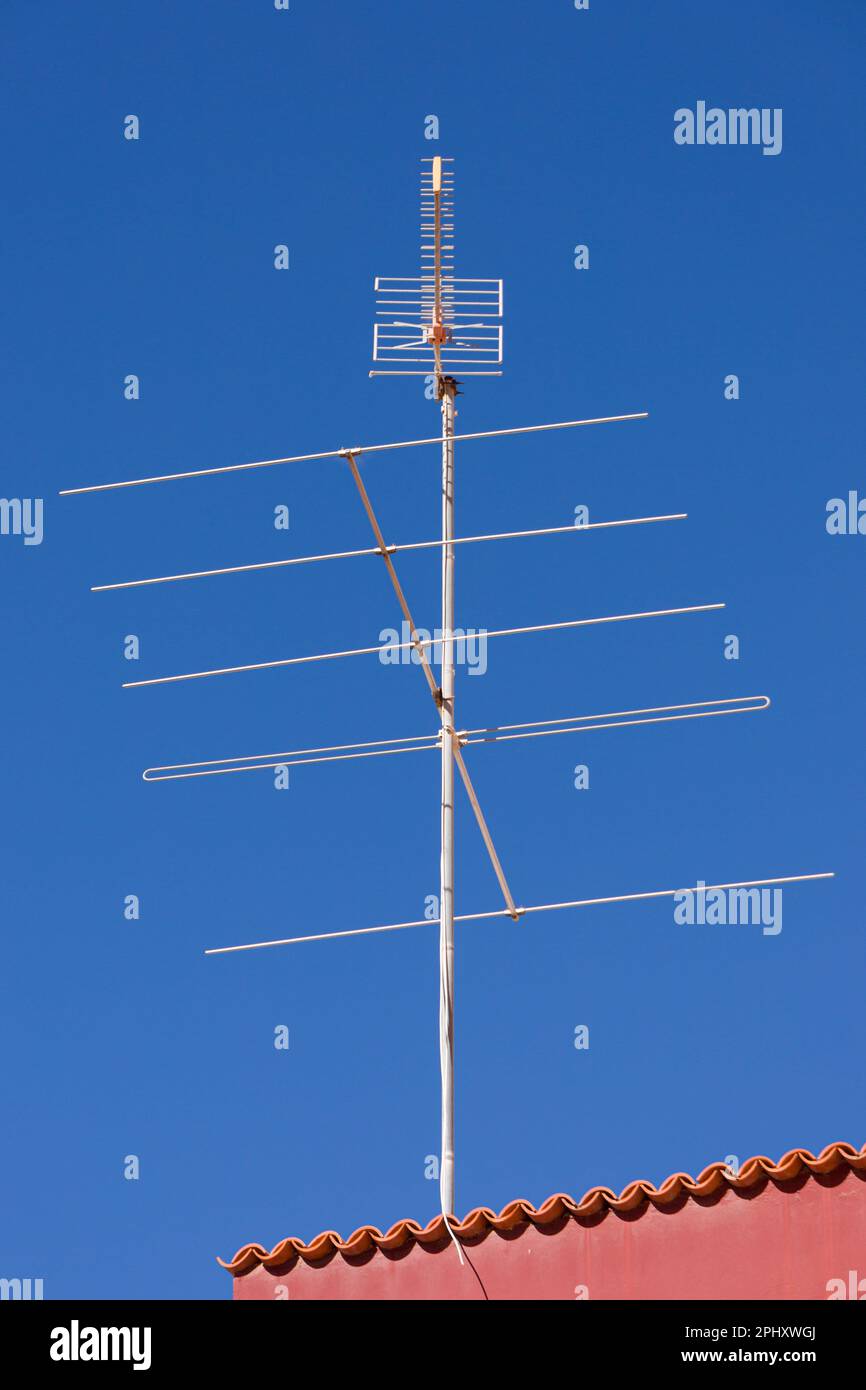 television antenna on a rooftop in front of a blue sky Stock Photo