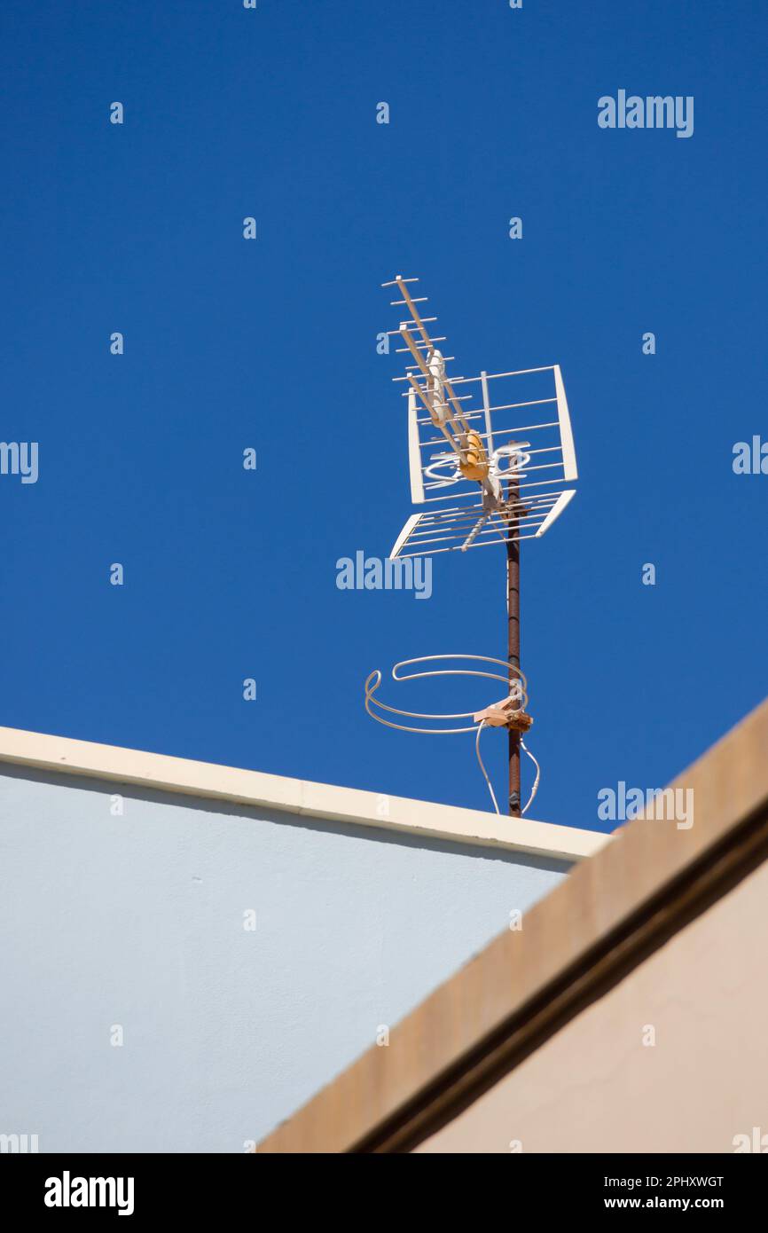 television antenna on a rooftop in front of a blue sky Stock Photo