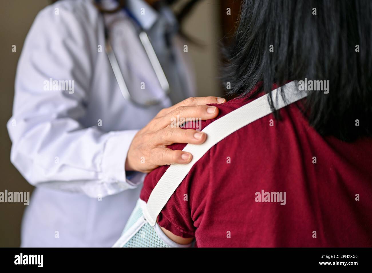 Close-up image of an orthopedic doctor touching a patient's shoulder to comfort and reassure. Stock Photo