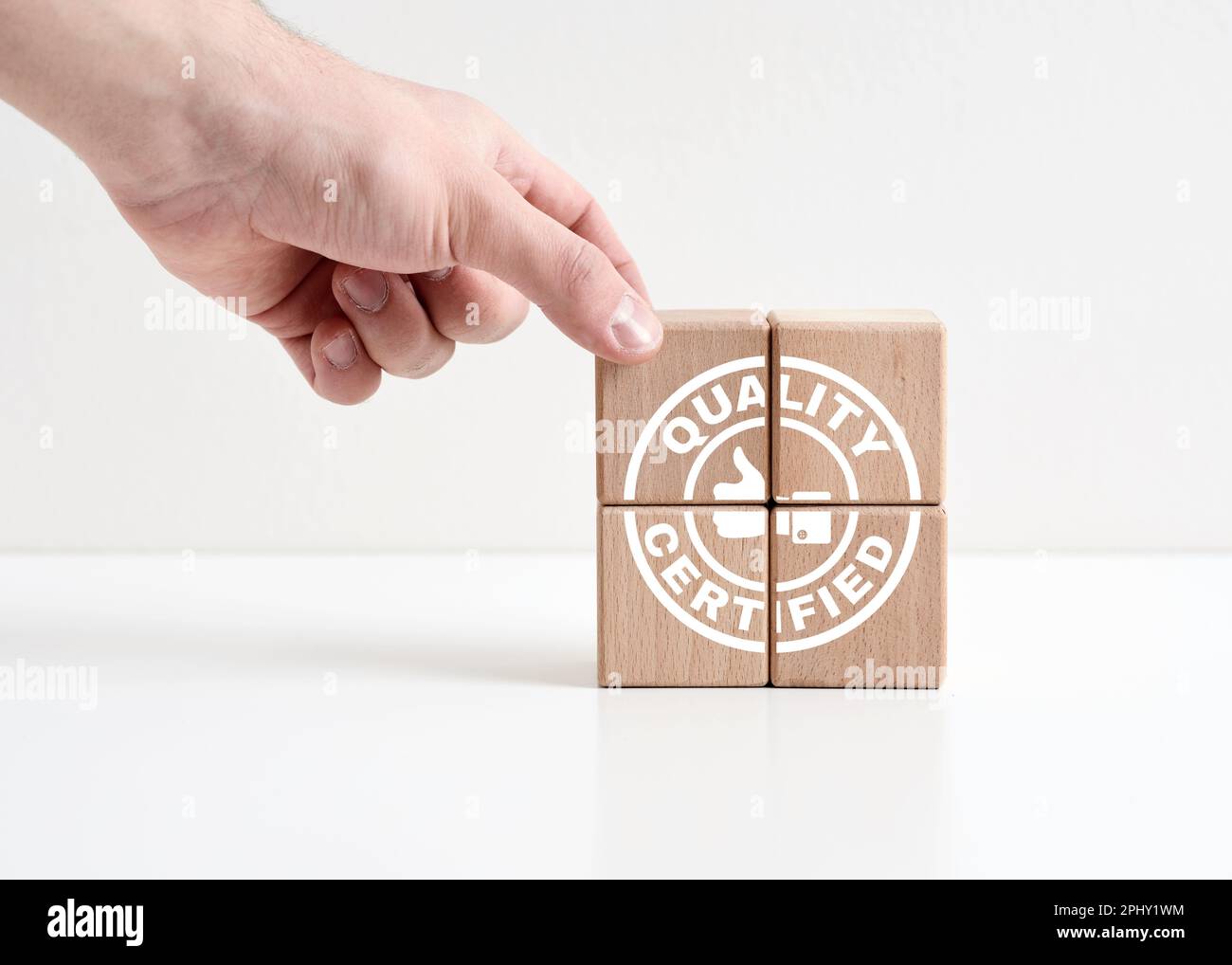 Quality certified concept. Business quality control and assurance. Warranty and meeting quality standards. Hand places wooden cubes with quality certi Stock Photo