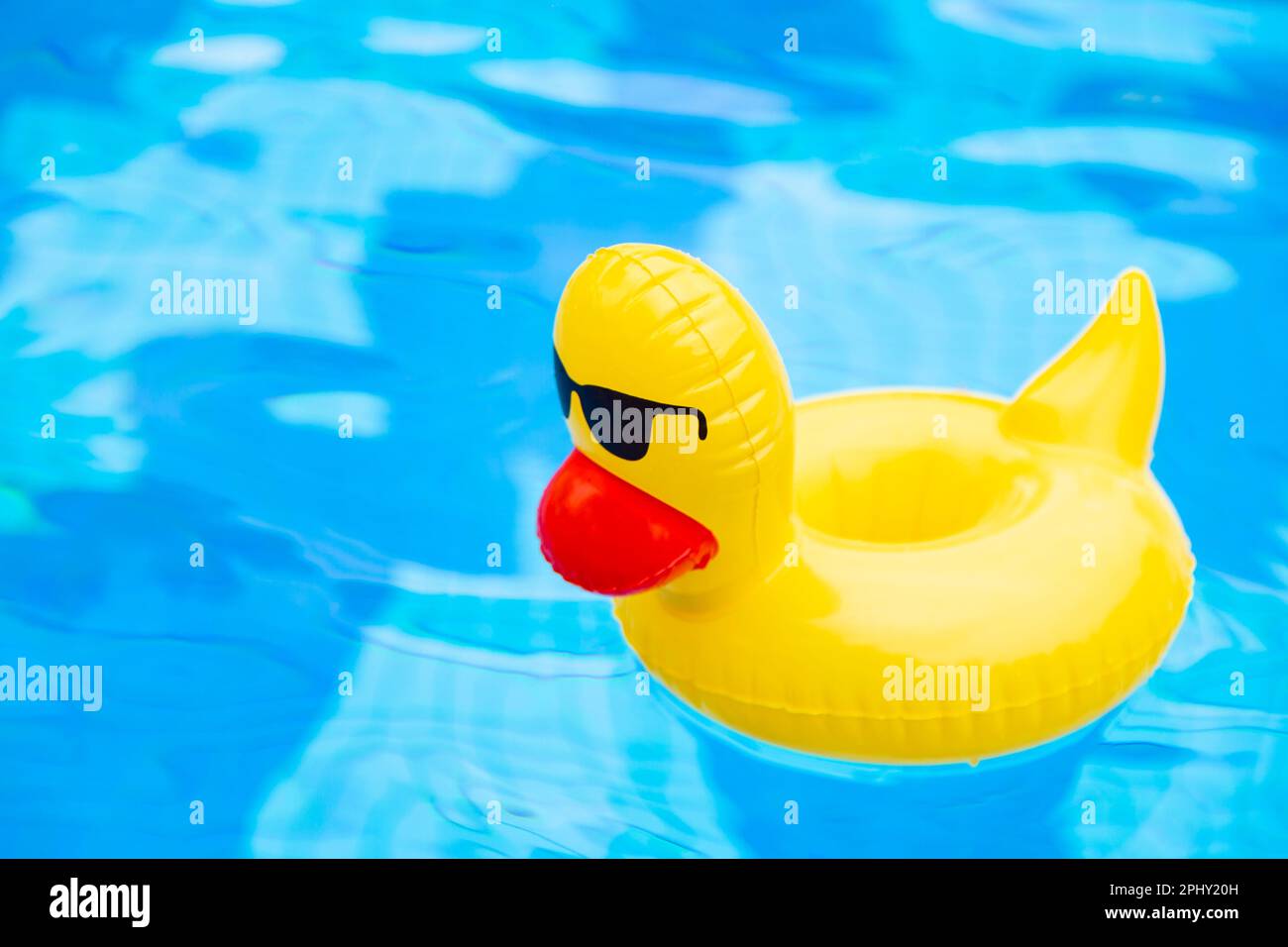 Inflatable Swimming duck Ring floating in the pool. Yellow plastic duck
