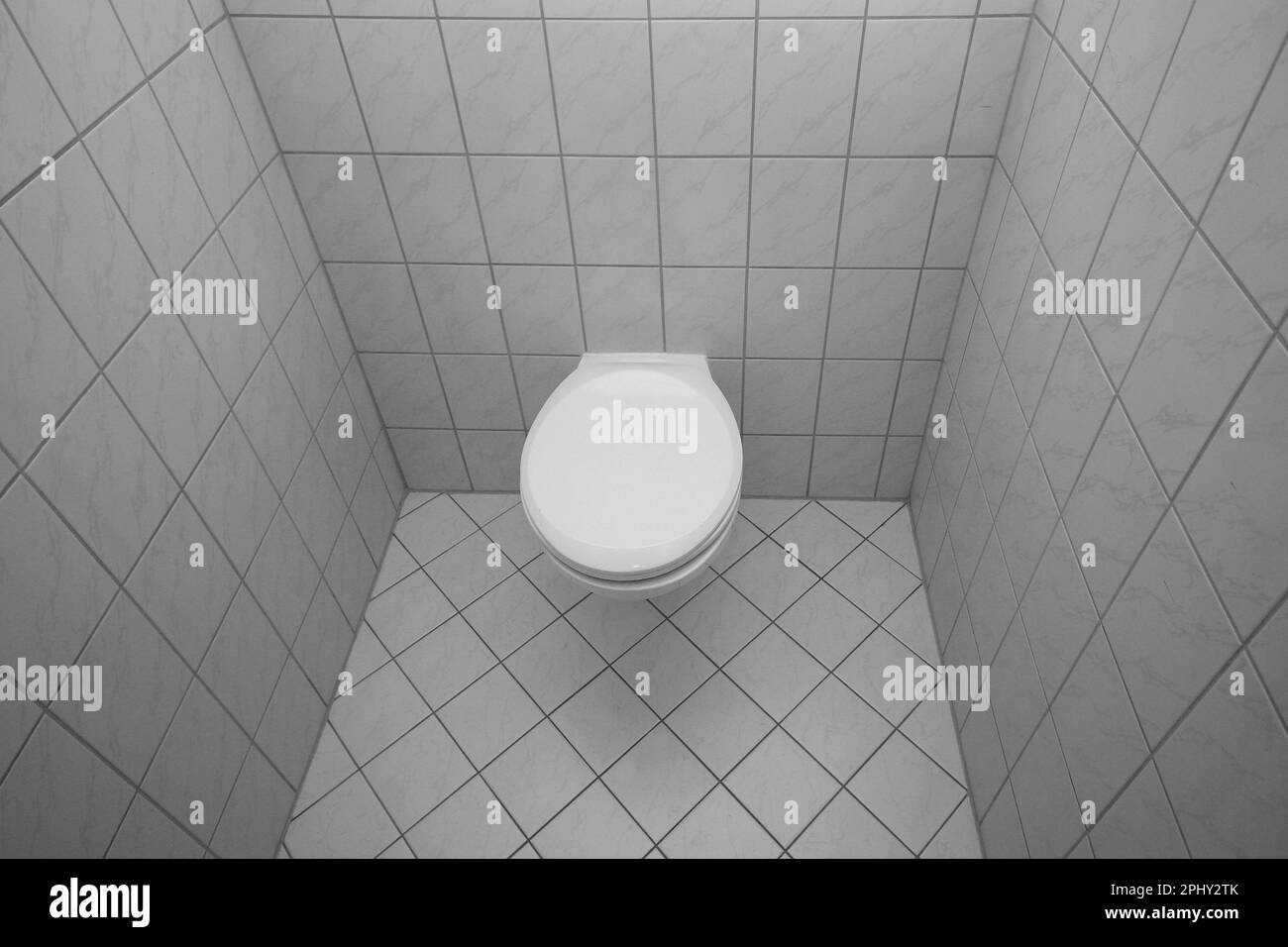modern wall-hung toilet in a white tiled toilet Stock Photo