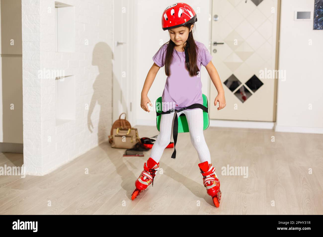 little girl is roller skating at home Stock Photo Alamy