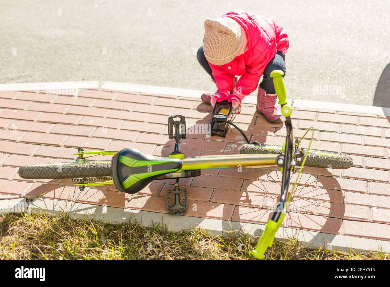 a little girl pumps up a bicycle tire Stock Photo Alamy