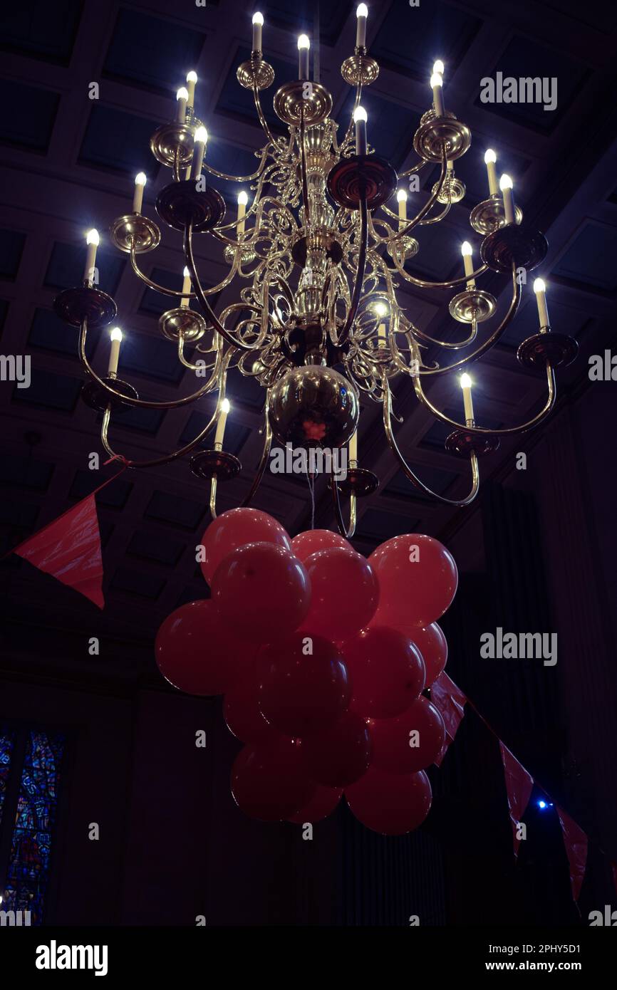 Close up of chandelier with orange balloons underneath Stock Photo