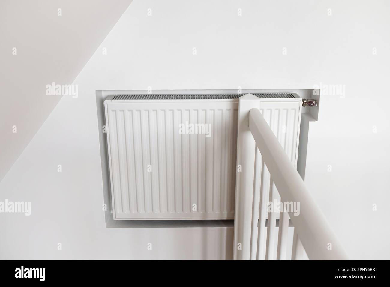 White hot water heater radiator built inside drywall indoors at home