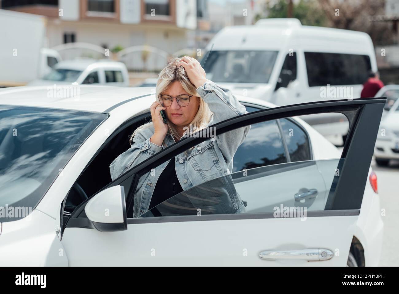 Woman picking up her car from impound lot. Girl using mobile phone at