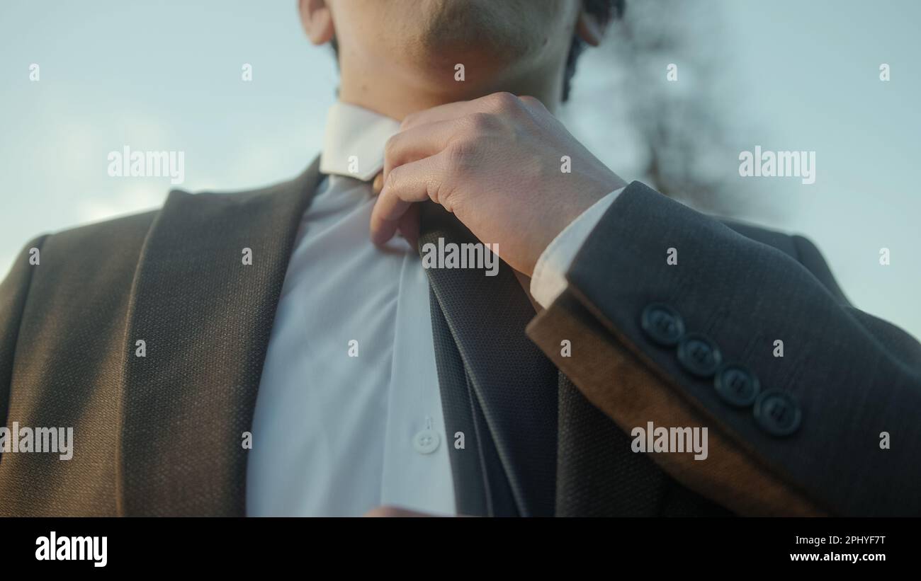 Young Businessman in a Suit Adjusts His Tie Stock Photo - Alamy