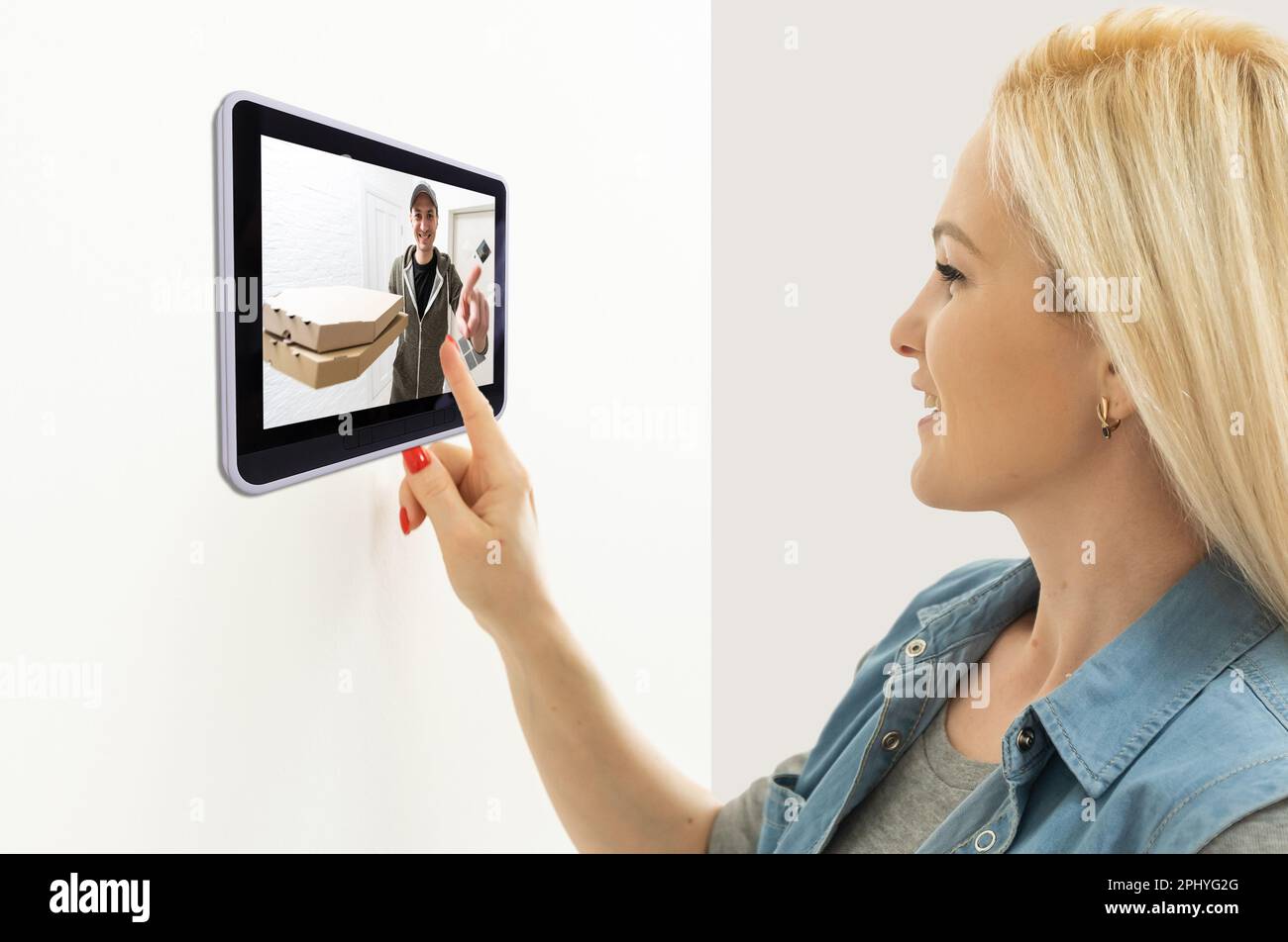 Delivery man ringing door bell on cctv secure camera system on tablet app Stock Photo