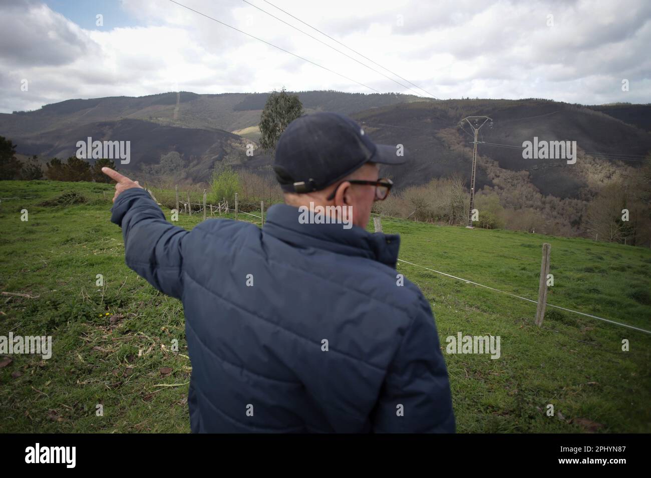 A man observes the mountain burned by a forest fire, on March 30, 2023, in  Baleira, Lugo, Galicia (Spain). The forest fire declared in Baleira (Lugo)  continues active and already affects 1,100