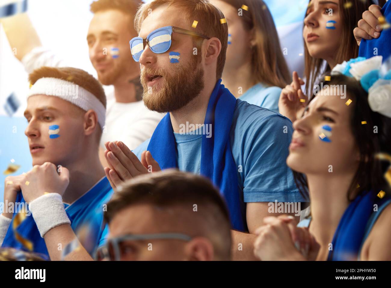 Praying to win. Emotional male and female sport fans watching football