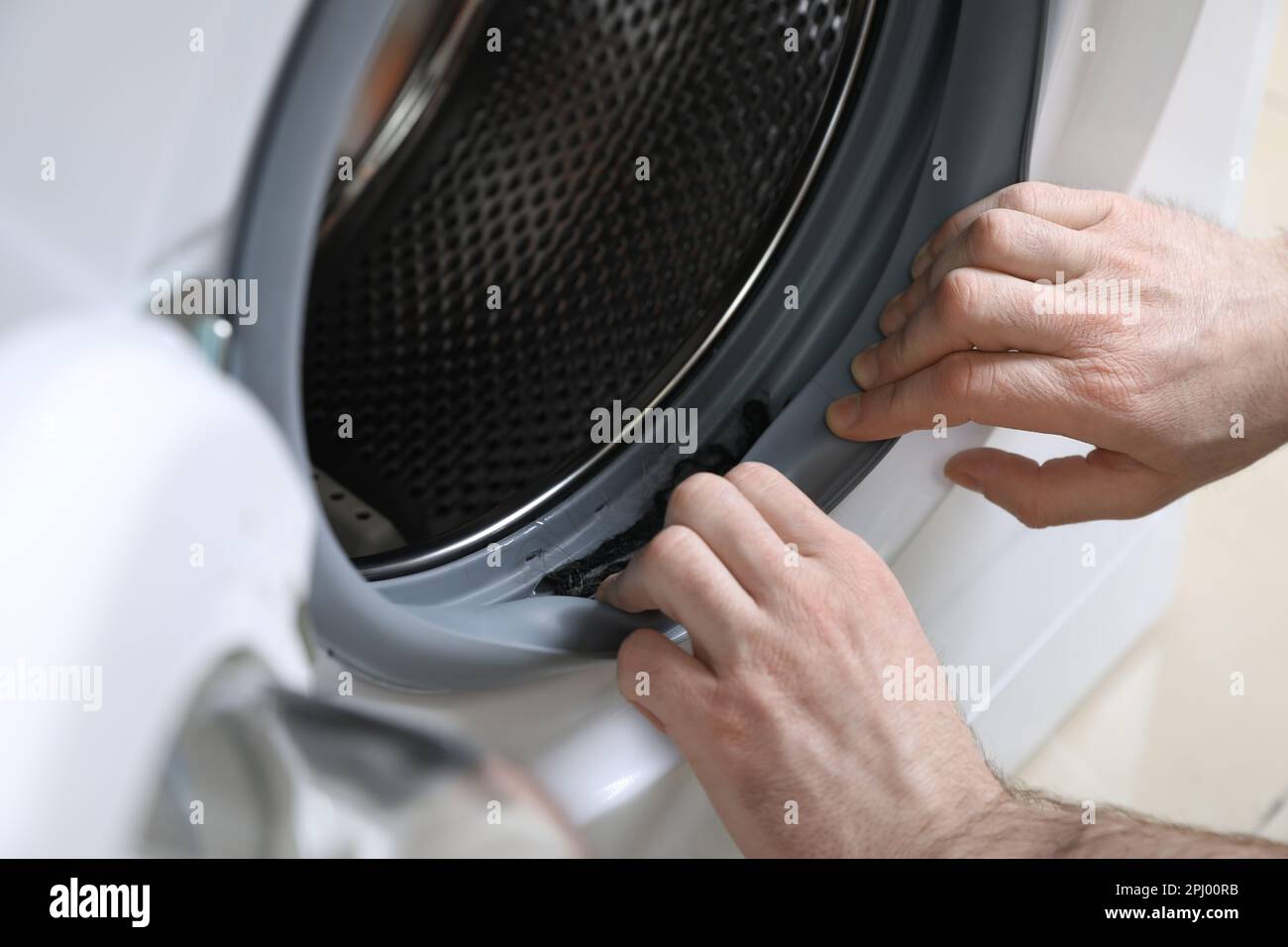 Man cleaning dirty seals of washing machine, closeup Stock Photo Alamy
