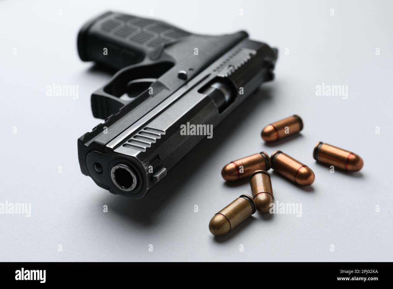 Semiautomatic pistol and bullets on light background, closeup Stock