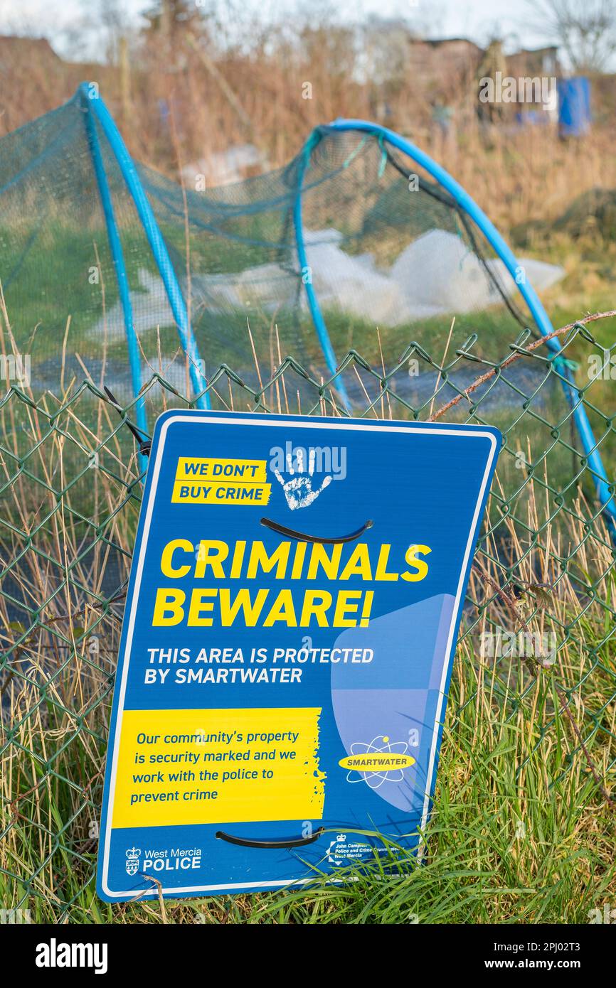 Close up of isolated West Mercia Police sign 'Criminals Beware, this area protected by smartwater' outdoors at a Worcestershire allotment, UK. Stock Photo