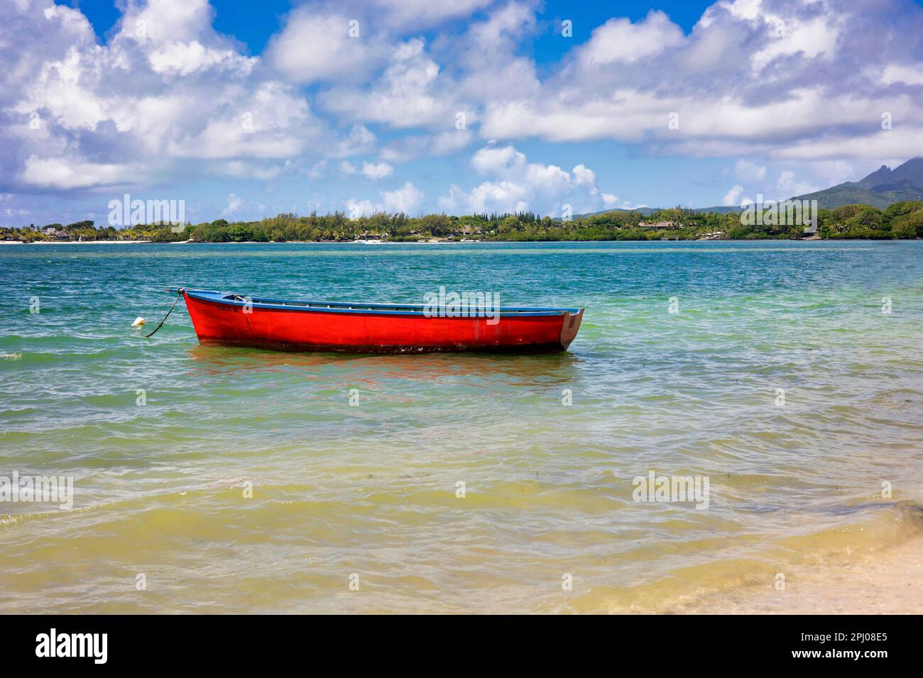 Red fishing boat lies tied up near the beach, east coast, Mauritius Stock Photo