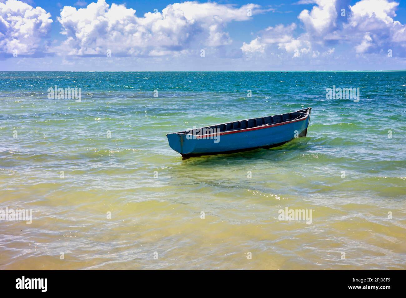 Blue fishing boat bobbing near the beach, east coast, Mauritius Stock Photo