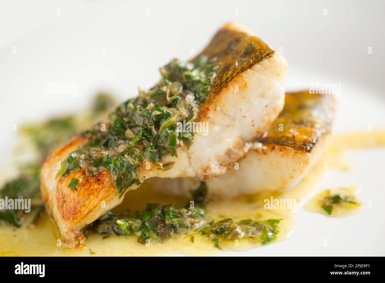 Two zander fillets that have been fried in oil and served with a caper, parsley, lemon and butter sauce. Zander were introduced into the UK in the 19t Stock Photo