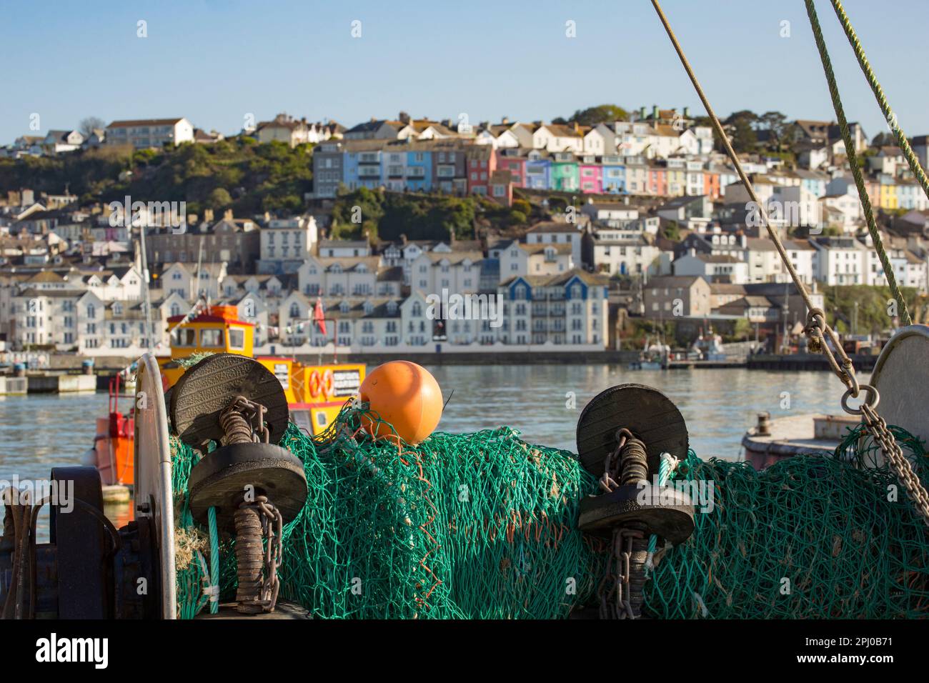 A view of Brixham seen from the stern of an inshore trawler with the trawl net in the foreground. Brixham Devon UK GB Stock Photo