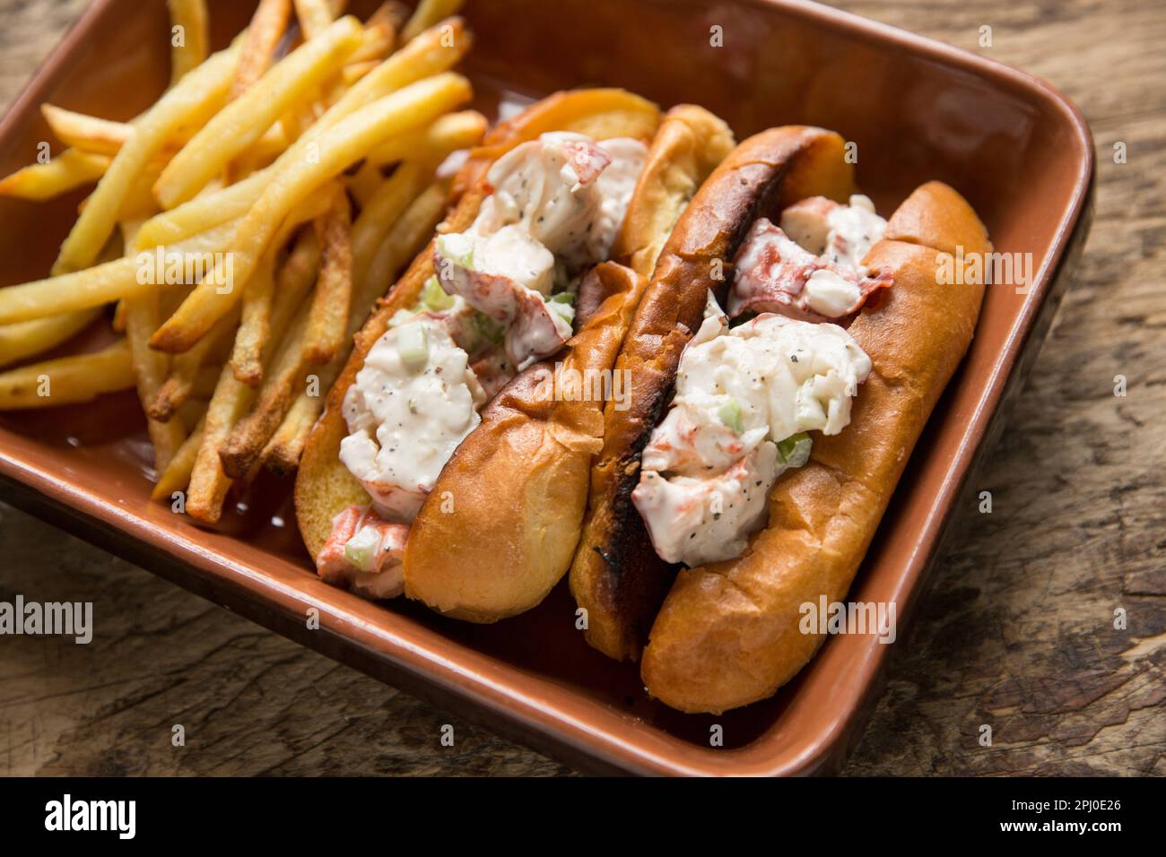 Lobster brioche rolls made with a boiled lobster, Homarus gammarus, caught in the English Channel. The lobster is combined with mayonnaise, diced cele Stock Photo