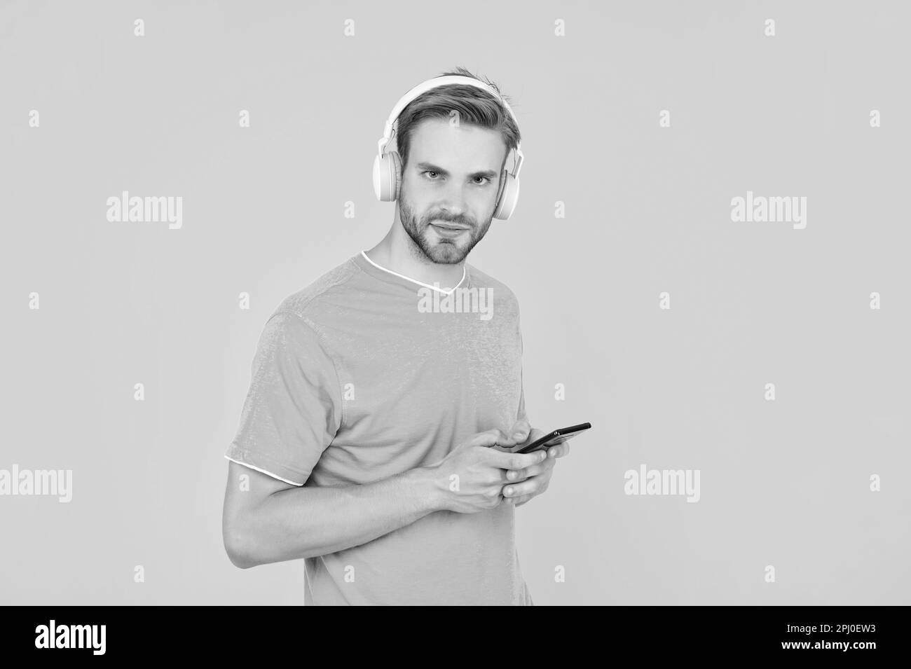 You are what you listen to. Guy listen to mobile music. Listening to playlist with headphones Stock Photo