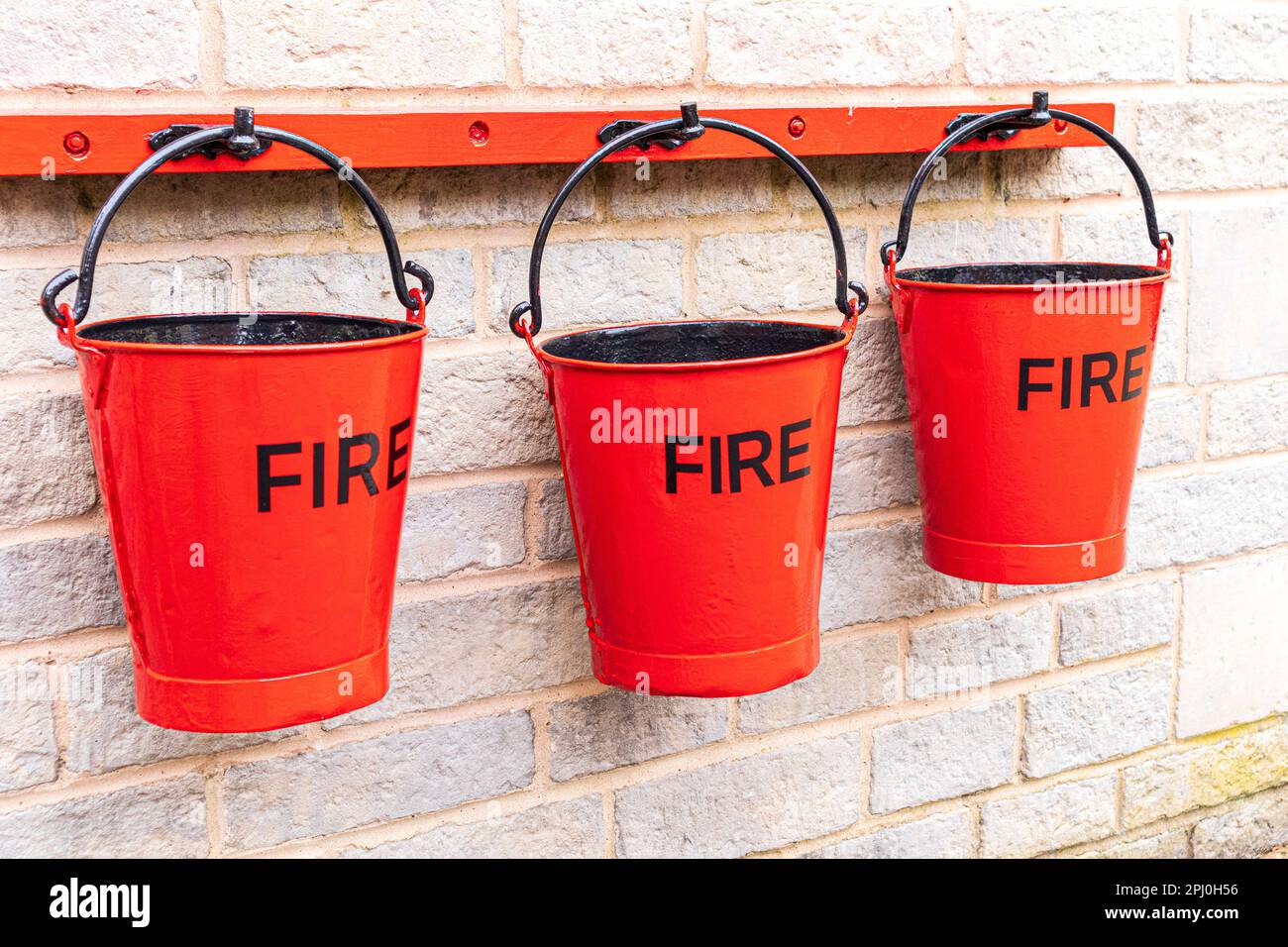 3 red fire buckets on Cheltenham Spa Station on the Gloucestershire Warwickshire Railway GWSR heritage steam railway, Cheltenham, Gloucestershire UK Stock Photo