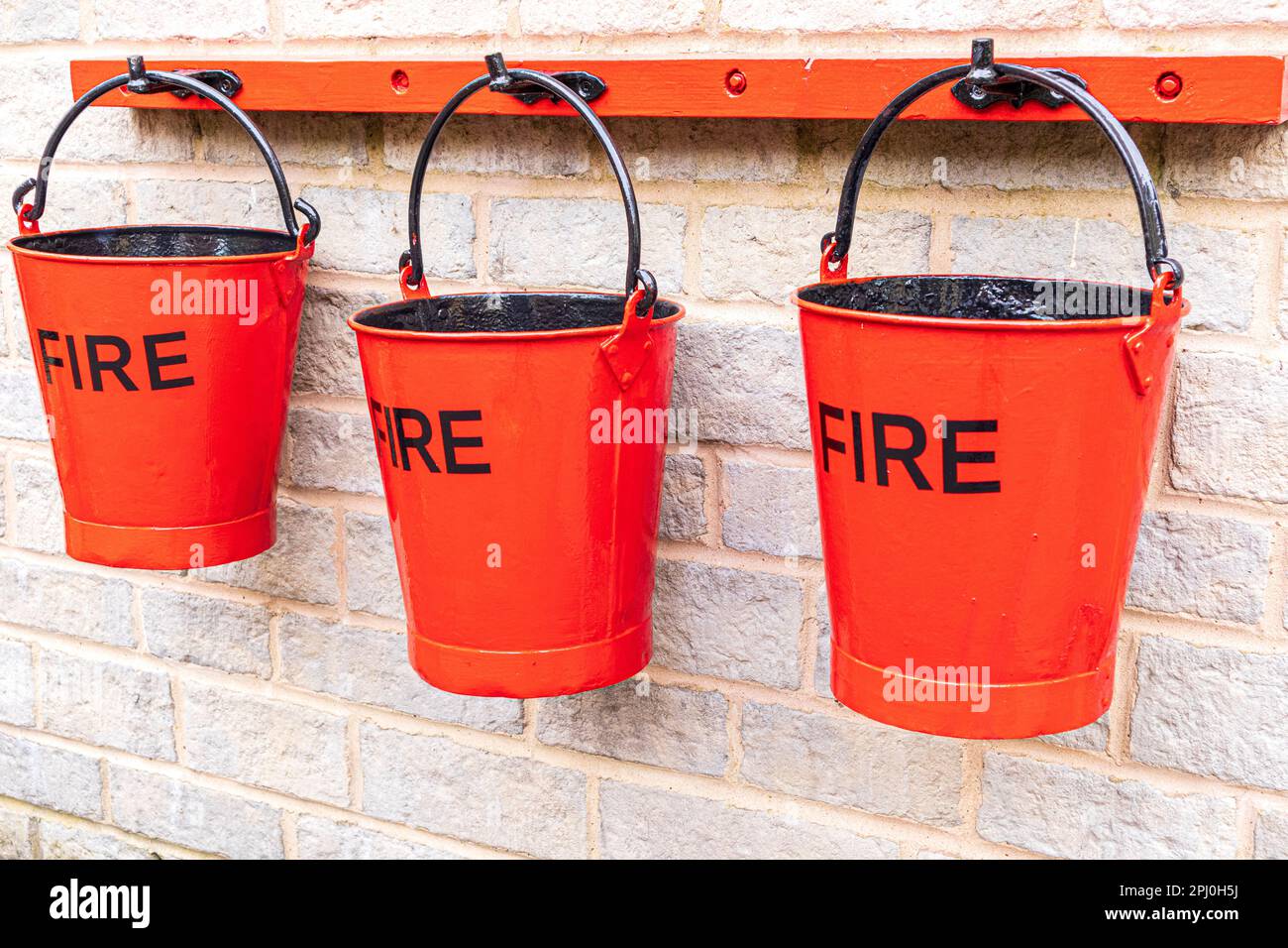 3 red fire buckets on Cheltenham Spa Station on the Gloucestershire Warwickshire Railway GWSR heritage steam railway, Cheltenham, Gloucestershire UK Stock Photo