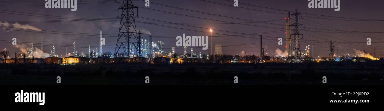 Stanlow Oil Refinery, Ellesmere Port in Cheshire, North West England. The lights glowing at night, processing and supplying petro chemicals to the UK Stock Photo