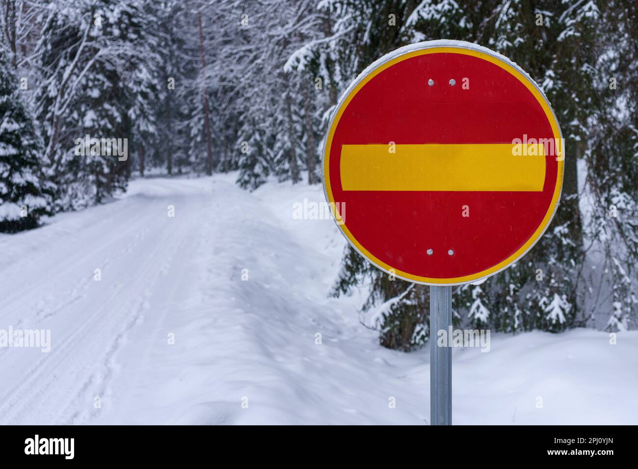 No entry traffic sign next to a snow covered road in winter. Hameenlinna, Finland. Stock Photo