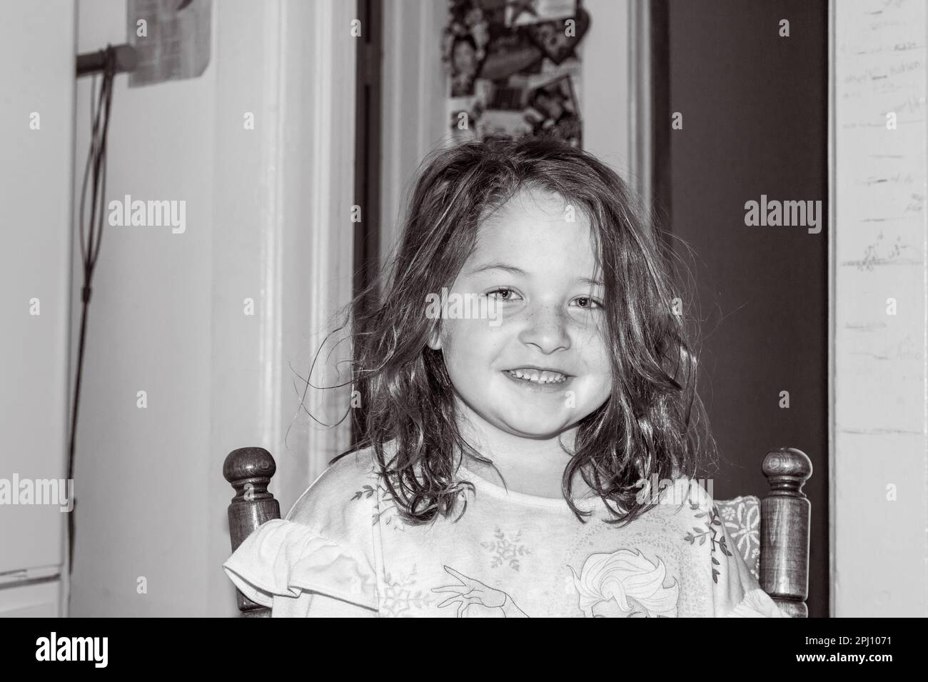 Happy young girl sitting at the kitchen table Stock Photo - Alamy