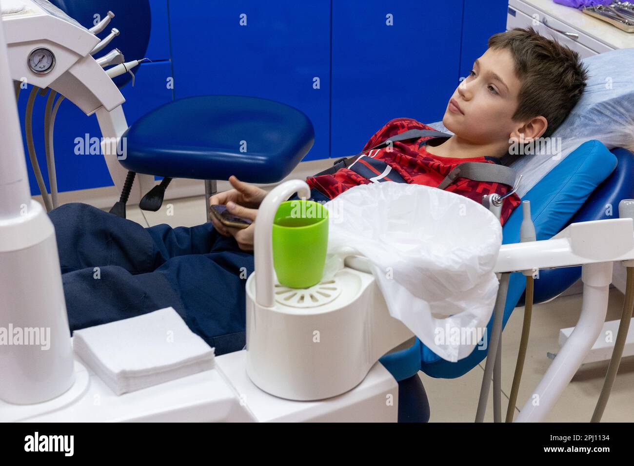 Serious teen boy in the dental chair in the clinic. waiting for dental