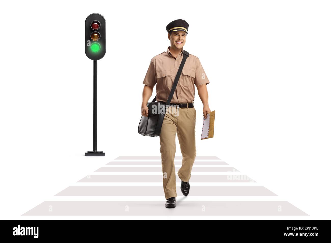 Full length portrait of a postman walking at a pedestrian crossing and a traffic light flashing green isolated on white background Stock Photo