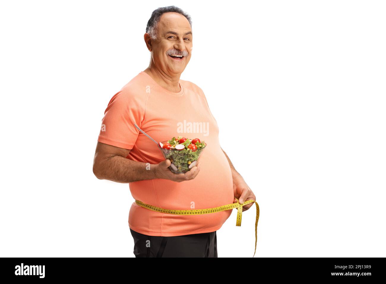 Mature man in sportswear holding a salad and measuring waist isolated on white background Stock Photo