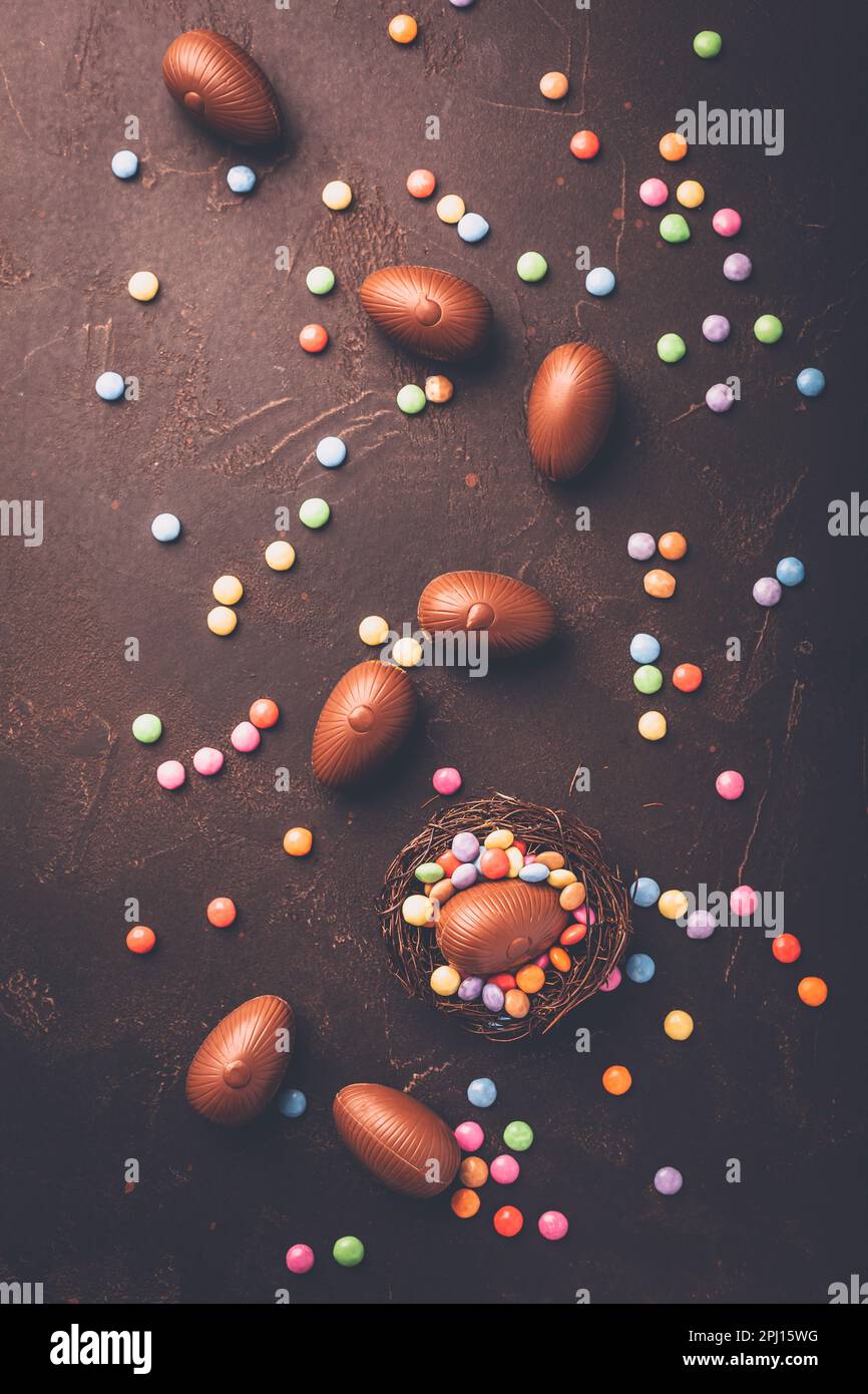 Sweet Easter - Chocolate eggs and colorful chocolate beans in bird nest Stock Photo