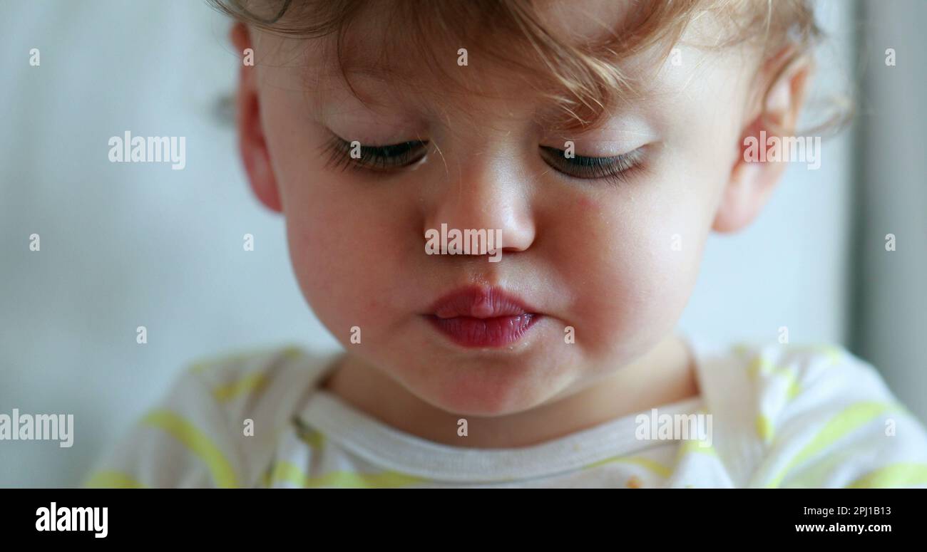 Portrait of baby one year old child eating snack, infant face chewing