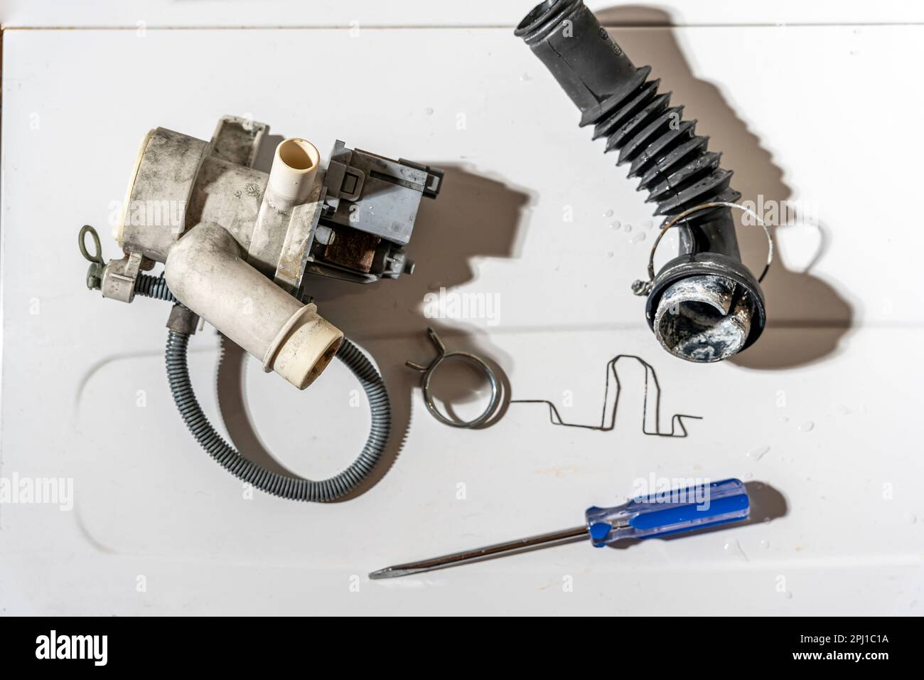 broken old washing machine water pump and rubber hoses Stock Photo Alamy