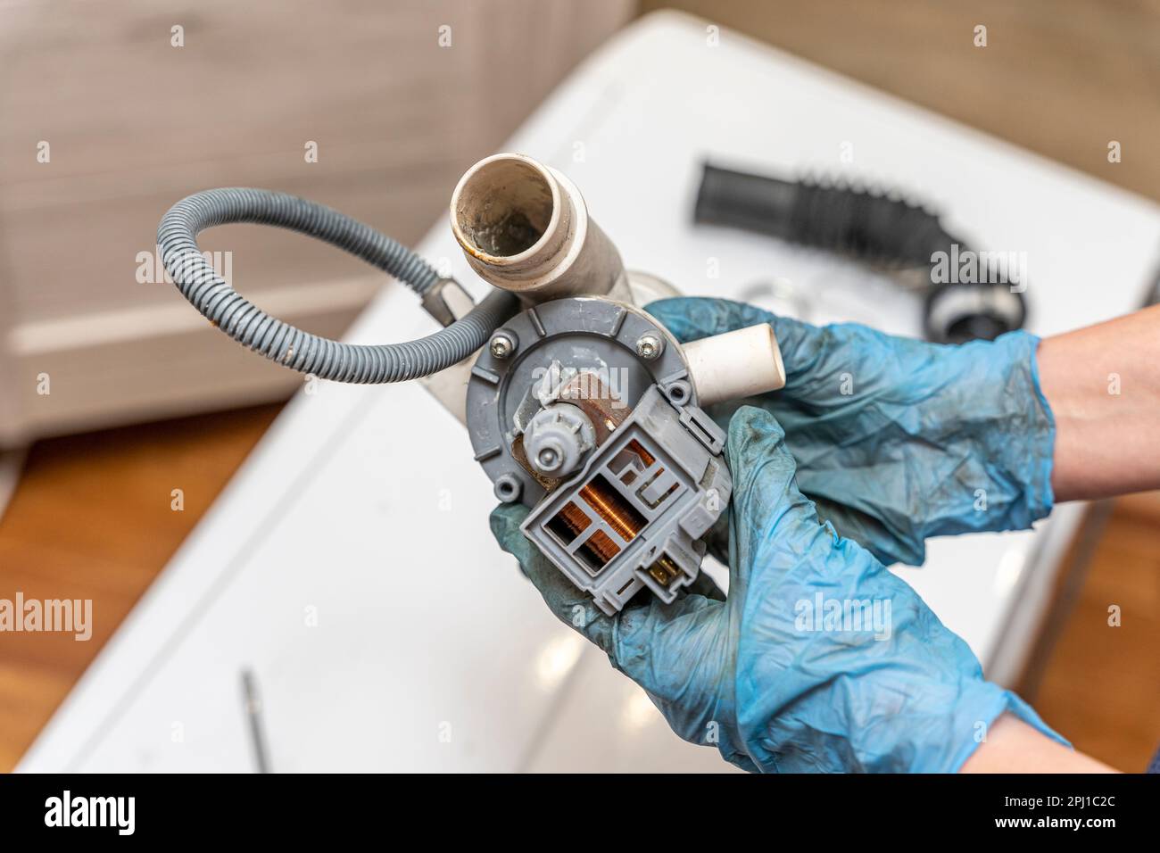 a broken old washing machine water pump in the hands of repairman Stock Photo Alamy