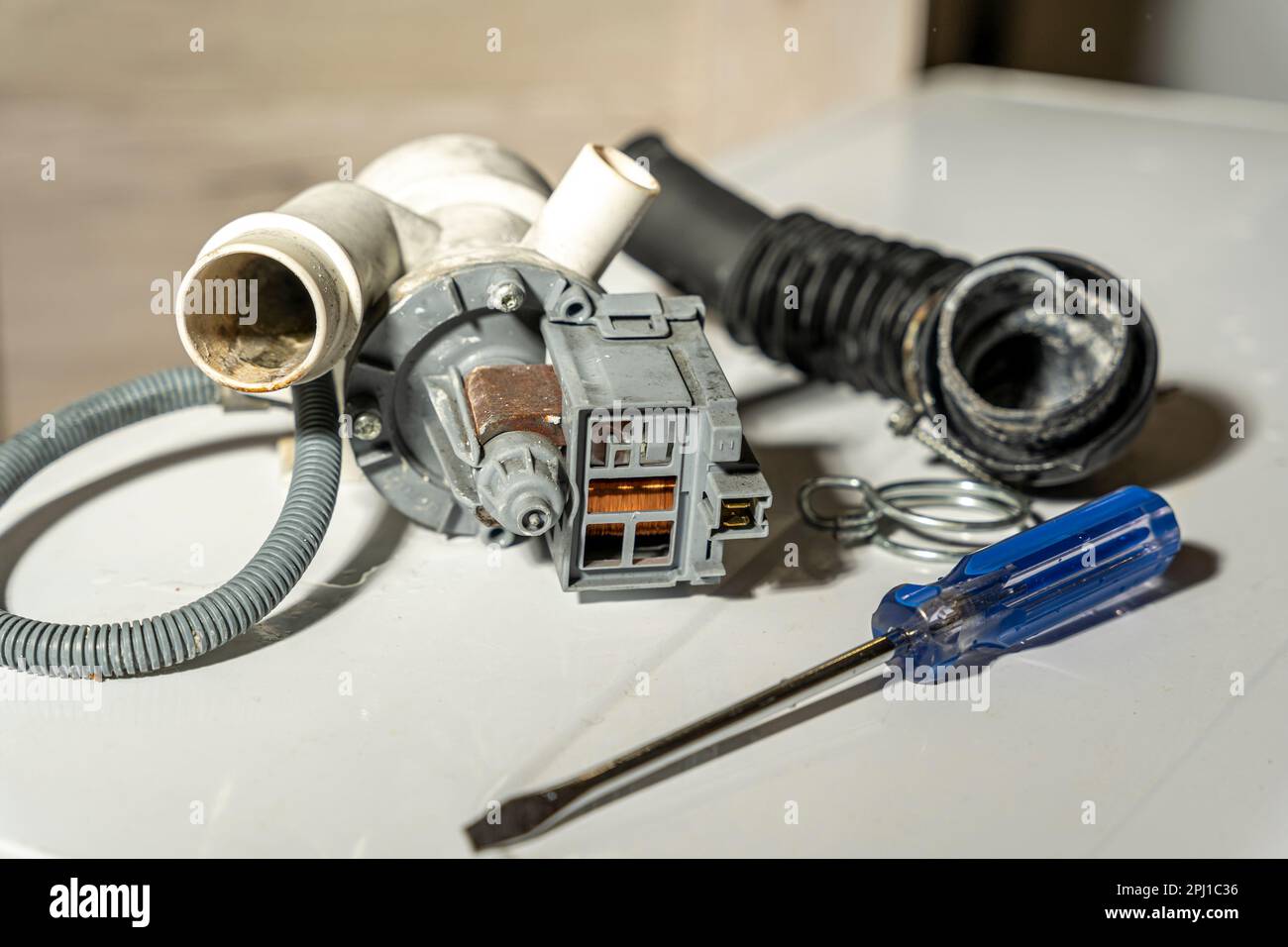 broken old washing machine water pump and rubber hoses Stock Photo Alamy