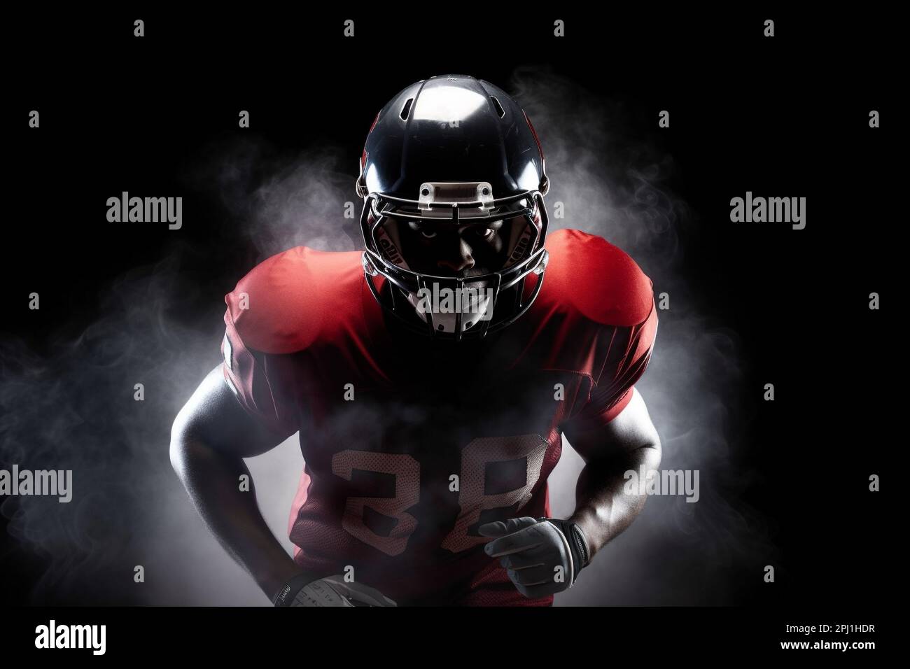 American football player on a dark background in smoke in black and red equipment Stock Photo